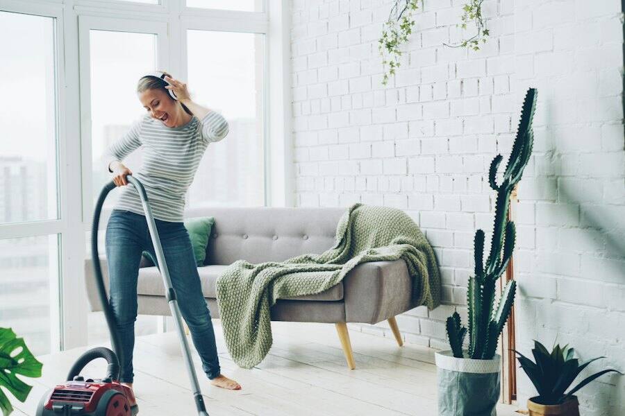 A cleaner vacuuming a modern condo living room